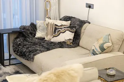 a living room with a couch with a blanket on it at Spacious 1BR & Study Burj Khalifa View, Downtown in Dubai
