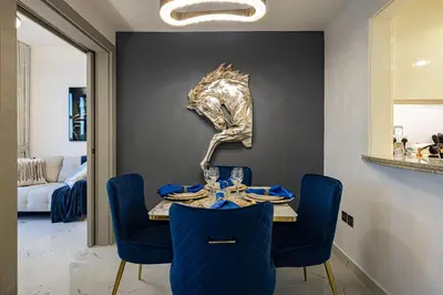 a dining room with a table and blue chairs at Spacious 1BR & Study Burj Khalifa View, Downtown in Dubai