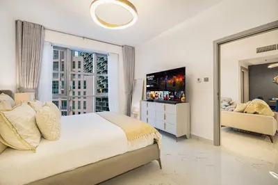 a bedroom with a bed and a large window at Spacious 1BR & Study Burj Khalifa View, Downtown in Dubai