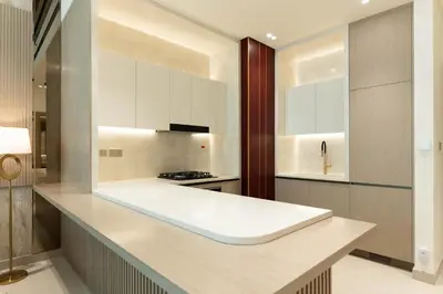 a kitchen with white cabinets and a counter top at Luxury Apartment with Private Pool in JVC in Dubai