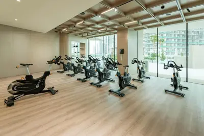a gym with a row of exercise bikes in a room at Luxury Apartment with Private Pool in JVC in Dubai