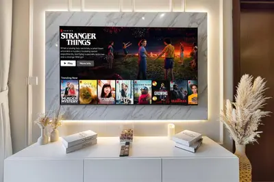 a tv hanging on a wall in a living room at Designer 2BR with Burj View 5 Min to Dubai Mall in Dubai