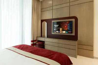 a bedroom with a bed and a tv on a wall at Luxury City Apartment with Private Pool in Dubai