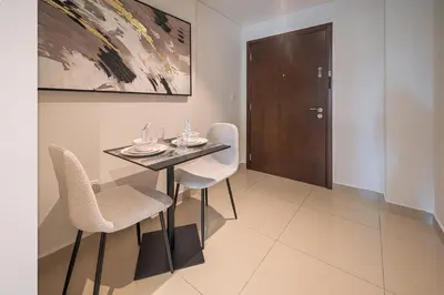 a dining room with a table and chairs at Elegant studio balcony boulevard view in Dubai
