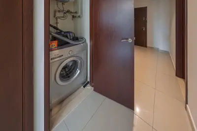 a kitchen with a washing machine in a room at Elegant studio balcony boulevard view in Dubai