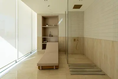 a bathroom with a bench and a glass shower at High-End Apartment with Balcony Pool in Dubai