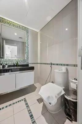 a bathroom with a toilet and a sink and a mirror at Elite Escapes - Glamorous Damac Heights - 2 BR in Dubai