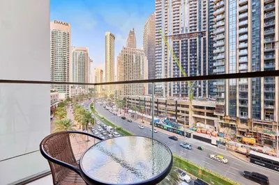 a table on a balcony with a view of a city at Premium 2BR Residence in Downtown Dubai in Dubai