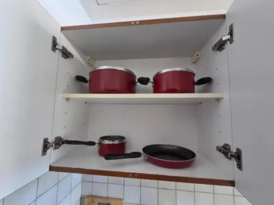two pots and pans on a shelf in a kitchen at Skycourts - Well furnished Studio apartment in Dubai