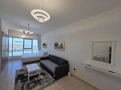 a living room with a couch and a tv at Skycourts - Well furnished Studio apartment in Dubai