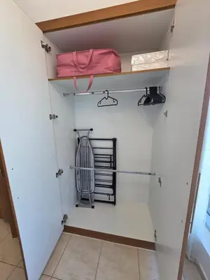 a walk in closet with white walls and shelves at Skycourts - Well furnished Studio apartment in Dubai