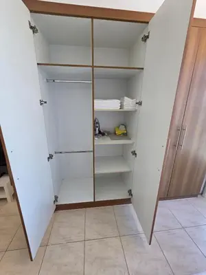a walk in closet with white walls and glass doors at Skycourts - Well furnished Studio apartment in Dubai