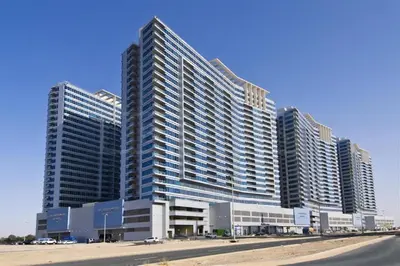 a large building with many windows on a beach at Skycourts - Well furnished Studio apartment in Dubai