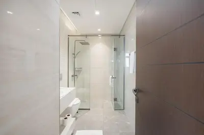 a bathroom with a shower and a toilet and a sink at Modern Chic 1BHK Nobles Tower by Czechin in Dubai