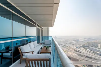 a balcony with white chairs and a view of a city at Gala Guests - Classic Opal Tower Suites Dubai Marina in Dubai