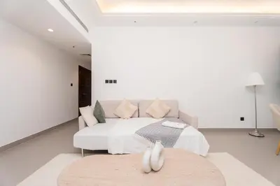 a living room with a white couch and a table at Gala Guests - Classic Opal Tower Suites Dubai Marina in Dubai