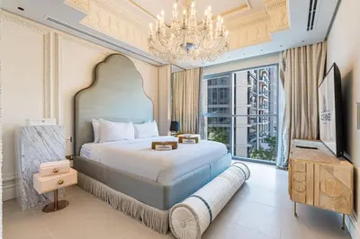 a bedroom with a large bed and a chandelier at Chic Central Downtown Home with Burj View in Dubai