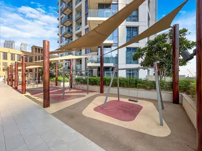 a playground in front of a tall building at Chic Central Downtown Home with Burj View in Dubai