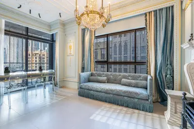 a living room with a couch and a chandelier at Chic Central Downtown Home with Burj View in Dubai