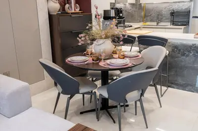 a dining room table with chairs and a vase with flowers at Stylish 1BHK Retreat at Nobles Tower, by Czechin in Dubai