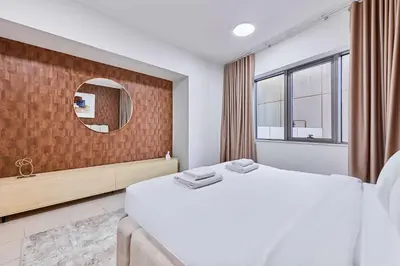 a bedroom with a large bed and a mirror at Greenview 2BHK Stay in Dubai