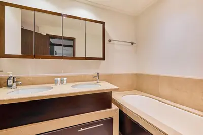a bathroom with two sinks and a bath tub at Greenview 2BHK Stay in Dubai