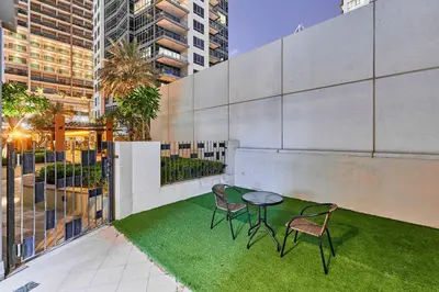 a patio with two chairs and a table and grass at Greenview 2BHK Stay in Dubai
