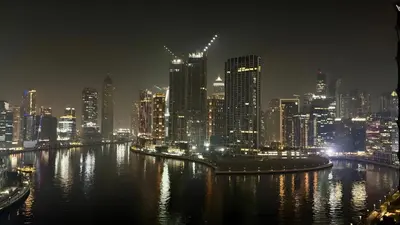 a night view of a city with a city skyline at Stunning Canal View Studio Business Bay in Dubai