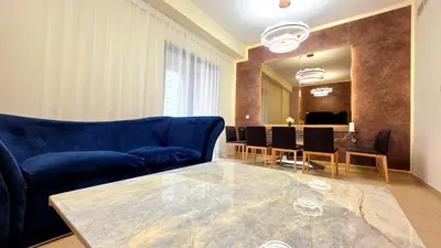 a living room with a blue couch and a table at Elan Rimal Bahar Suites, 1min walk to the Sea! Prime location JBR Beach Front in Dubai