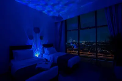 a blue room with two beds and a window at Luxury 3BR in Mada Residences - Walk to Dubai Mall in Dubai