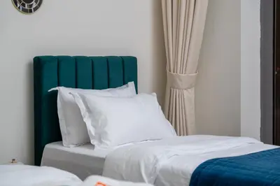 a bed with a green headboard and white pillows at Luxury 3BR in Mada Residences - Walk to Dubai Mall in Dubai