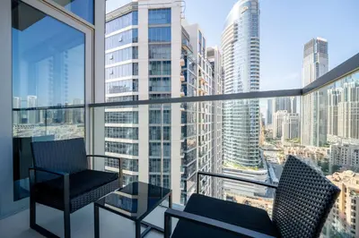 a balcony with two chairs and a view of the city at Marcopolo - Signature High-Floor Apartment Facing Burj Khalifa in Sabkhah
