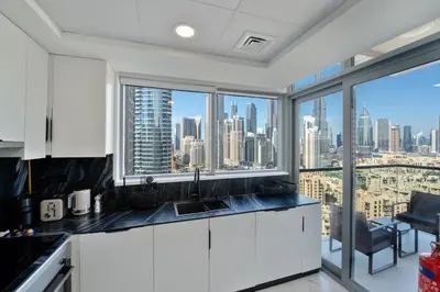 a kitchen with a view of a city skyline at Marcopolo - Signature High-Floor Apartment Facing Burj Khalifa in Sabkhah
