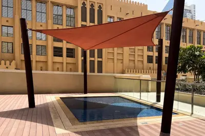 a large orange umbrella in front of a building at Marcopolo - Signature High-Floor Apartment Facing Burj Khalifa in Sabkhah