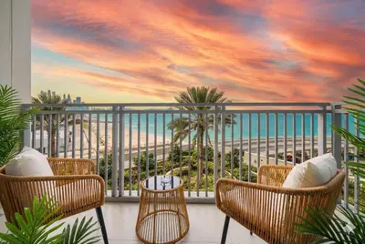 a balcony with a view of the ocean and palm trees at Emaar 52 42! Iconic Sea-View! Dubai Marina in Dubai
