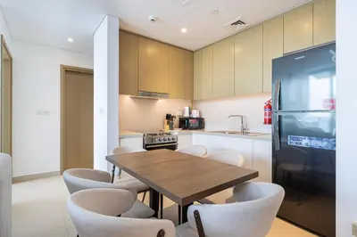 a kitchen with a table and chairs and a refrigerator at Emaar 52 42! Iconic Sea-View! Dubai Marina in Dubai