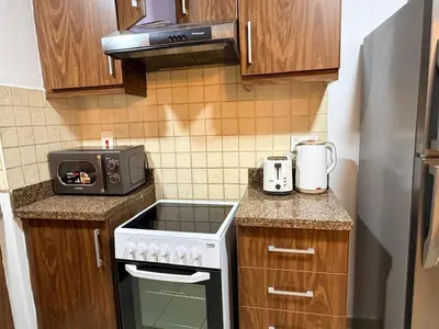 a small kitchen with a stove and a microwave at Capital Stay - 2 Bed Apt in Business Bay in Dubai