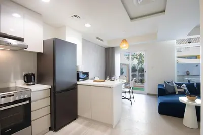 a kitchen and living room with a blue couch at 3BR Townhouse Rooftop Terrace Just Cavalli in Dubai