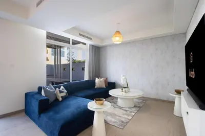 a living room with a blue couch and a table at 3BR Townhouse Rooftop Terrace Just Cavalli in Dubai