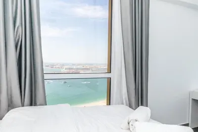 a bedroom with a large window with a view of the ocean at Luxury 2BR Sea View Jumeirah Beach Residence in Dubai