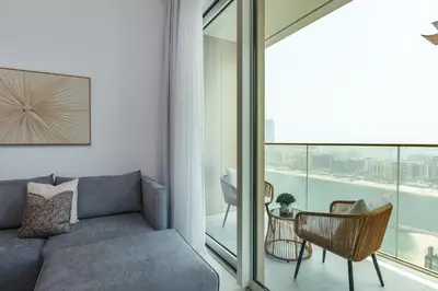 a living room with a couch and a balcony at Grand Bleu 1, Emaar Beachfront - Mint Stay in Dubai