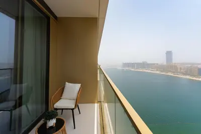 a balcony with a chair and a view of the water at Grand Bleu 1, Emaar Beachfront - Mint Stay in Dubai