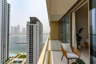 a balcony with a chair and a view of the city at Grand Bleu 1, Emaar Beachfront - Mint Stay in Dubai