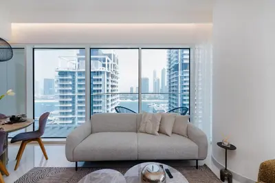 a living room with a couch and a large window at Grand Bleu, Emaar Beachfront - The Mint Stay in Dubai