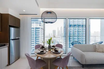 a kitchen and living room with a table and chairs at Grand Bleu, Emaar Beachfront - The Mint Stay in Dubai