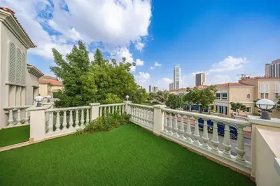 a balcony with a white fence and green grass at Luxury Spacious 5 bed Villa Pool and Garden in Dubai