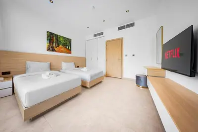 a bedroom with two beds and a flat screen tv at Luxury Spacious 5 bed Villa Pool and Garden in Dubai