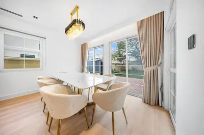 a dining room with a white table and chairs at Luxury Spacious 5 bed Villa Pool and Garden in Dubai