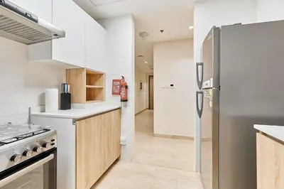 a kitchen with white counters and a refrigerator at 2BHK Canal View Stay-Business Bay in Dubai