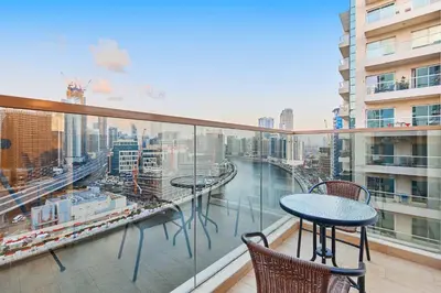 a balcony with a table and chairs and a view of a city at 2BHK Canal View Stay-Business Bay in Dubai